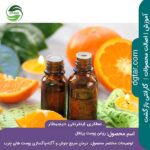 خرید اینترنتی روغن پوست پرتقال از عطاری اینترنتی دیجیطار (دو شیشه مشکی همراه شمع روشن ماساژ که حاوی روغن پوست پرتقال هستند کنار پرتقال های بریده شده)